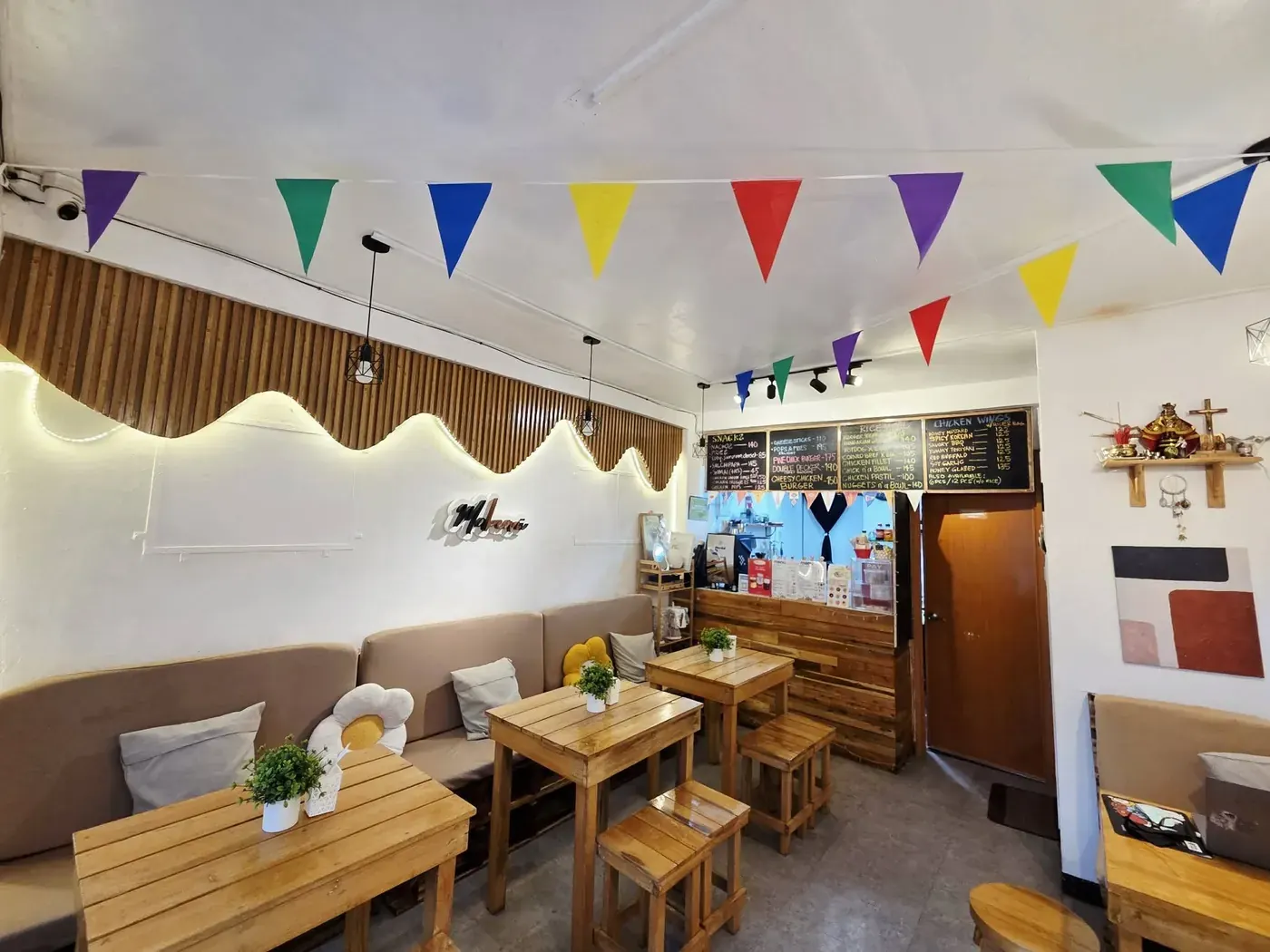 Inside Mabeani Coffee: wooden tables, warm lights and colorful bunting