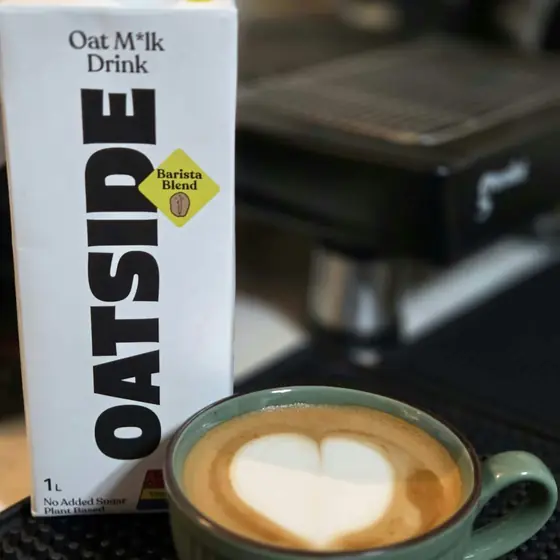A hot oat milk latte with heart latte art