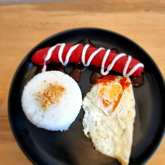 Red hotdog with fried egg and garlic rice