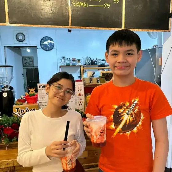 Two customers smiling with their drinks