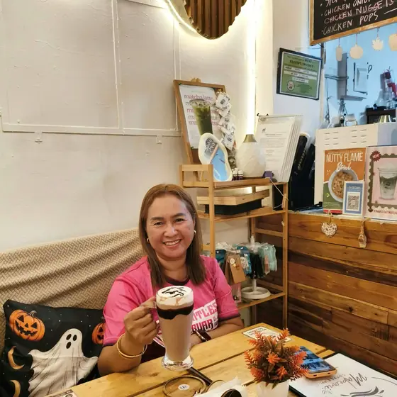 A customer enjoying an iced latte by the window seat