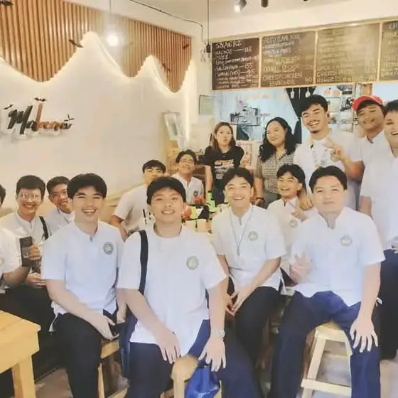 A big group of students posing together at the cafe