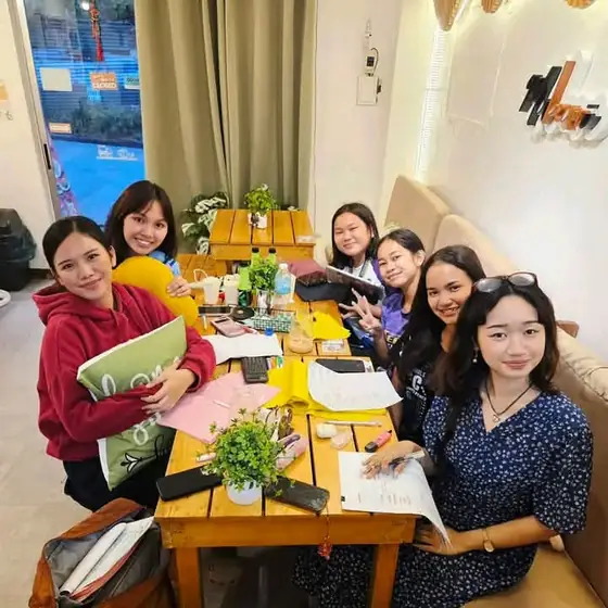 Friends studying and chatting over drinks