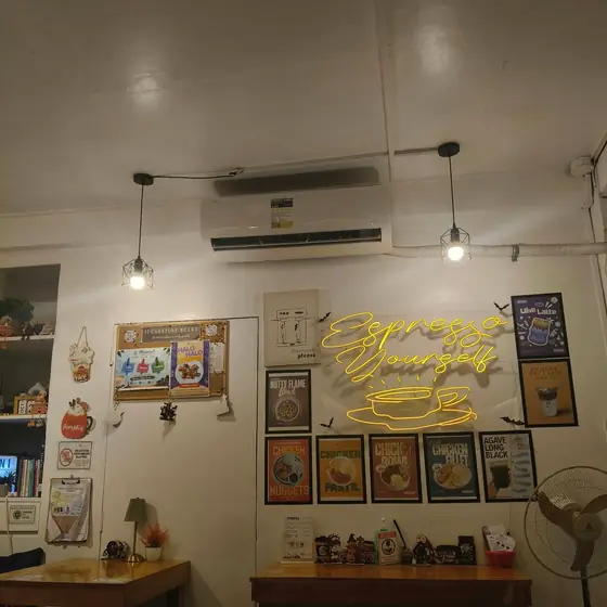 The yellow "Espresso Yourself" neon sign inside Mabeani Coffee