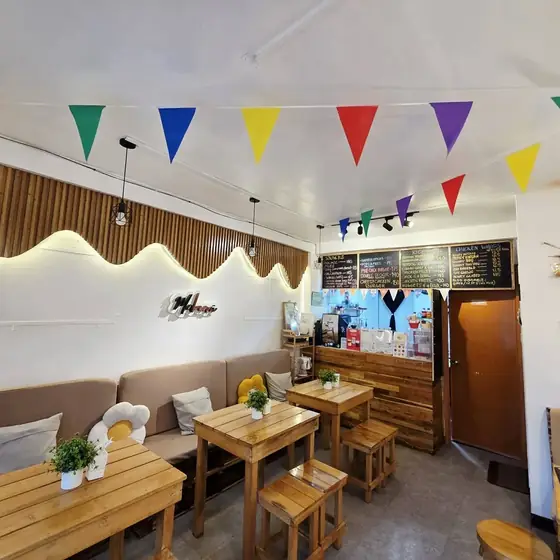 Wooden tables, warm lights and colorful bunting inside the cafe