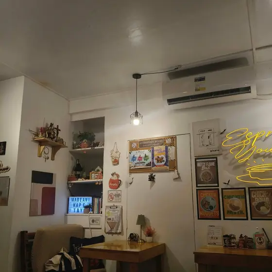A cozy corner with an armchair, shelves and the neon sign